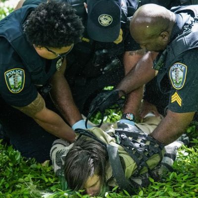 Três policiais prendem um estudante durante protesto pró-Palestina em Atlanta