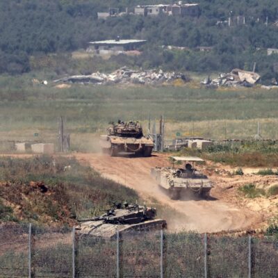 Veiculos militares israelenses trafegam por área próxima à divisa com a Faixa de Gaza
