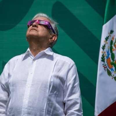 O presidente mexicano, Andrés Manuel López Obrador, assistindo à passagem do eclipse solar de óculos nesta segunda-feira