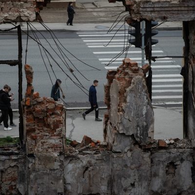 Buraco provocado por um míssil russo em uma escola em Kharkiv permite observar pedestres nas ruas