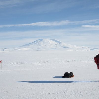 Um residente da Estação de McMurdo e o Monte Érebo ao fundo