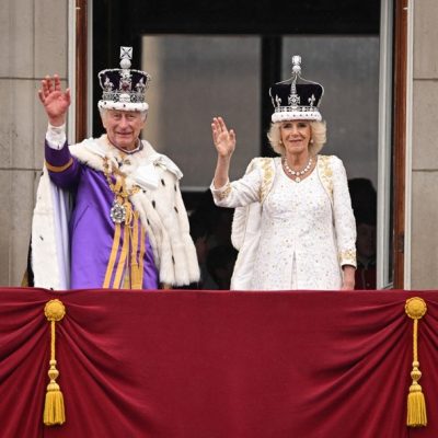 O rei Charles e a rainha Camilla acenando da varanda do Palácio de Buckingham