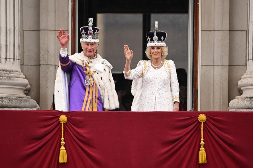 O rei Charles e a rainha Camilla acenando da varanda do Palácio de Buckingham