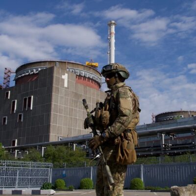 Soldado russo patrulha um dos prédios da central nuclear de Zaporíjia, na Ucrânia