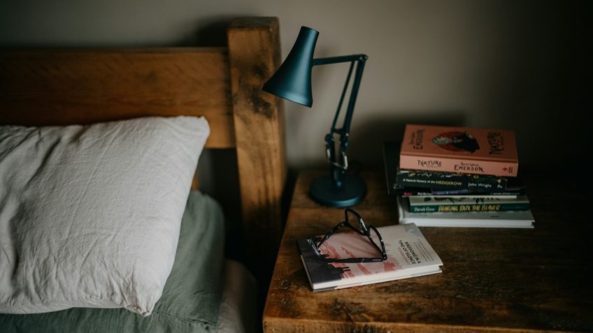 Livros em cabeceira de cama