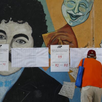 Um homem verifica seu número de identificação nos cadernos eleitorais durante o referendo consultivo sobre a soberania venezuelana em relação ao Essequibo, hoje controlado pela Guiana