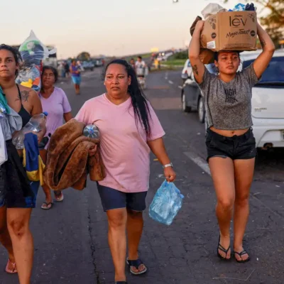 People walk carrying donated items in Eldorado do Sul, in Rio Grande do Sul, Brazil, May 6, 2024. REUTERS/Amanda Perobelli