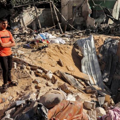 Crianças ao lado de cratera aberta por bombardeio israelense em Rafah