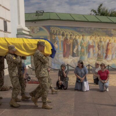 Pessoas se ajoelham enquanto soldados da Ucrânia carregam caixão de oficial morto na região de Donetsk