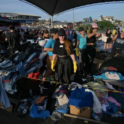 Um voluntário organiza roupas doadas para serem distribuídas entre os evacuados das enchentes, no bairro Humaitá, em Porto Alegre, Rio Grande do Sul