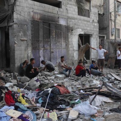 Situação humanitária em Rafah: palestinos sentam-se junto aos escombros de uma casa de família que foi atingida durante bombardeio