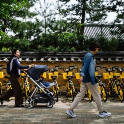 Mãe passeia com o filho no carrinho: cena cada vez mais rara em Seul