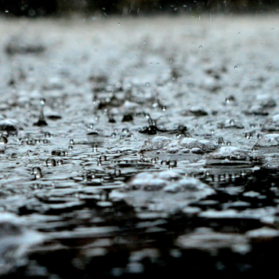 Foto ilustrativa de pingos de chuva caindo no chão.