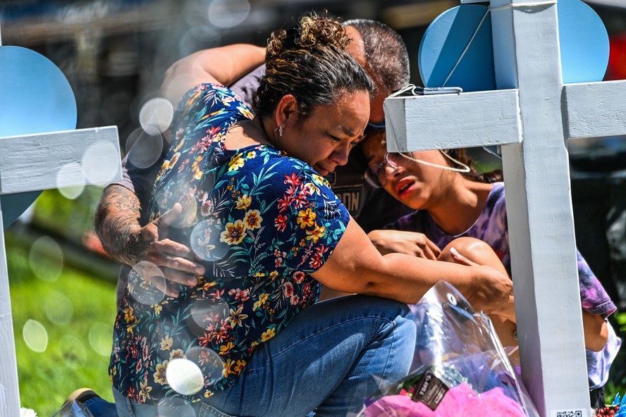 Pessoas choram no memorial improvisado no Tribunal do Condado de Uvalde em Uvalde, Texas. A polícia foi alvo de revolta da população que questionou a demora em neutralizar o atirador que matou mais de 20 pessoas na escola da comunidade de maioria mexicana