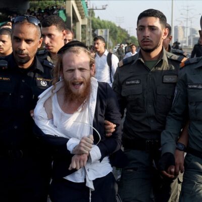 Polícia israelense detém manifestante enquanto tenta dispersar judeus ultraortodoxos que bloqueavam rodovia em protesto contra possíveis mudanças nas leis do alistamento militar