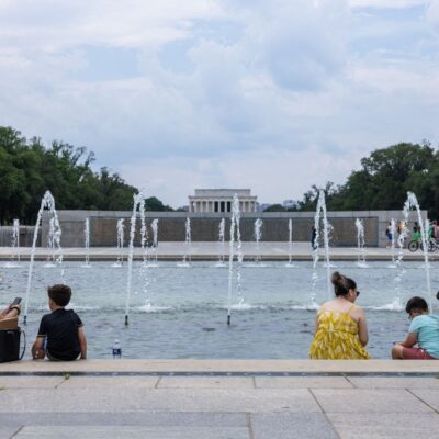 Pessoas tentam se refrescar no lago em frente ao monumento da II Guerra Mundial, em Washington, onde a temperatura superou 35C