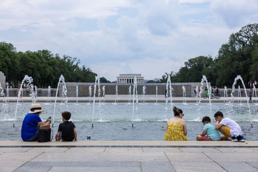 Pessoas tentam se refrescar no lago em frente ao monumento da II Guerra Mundial, em Washington, onde a temperatura superou 35C
