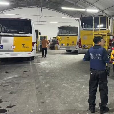 Agentes de segurança em garagem com ônibus da UPBus, em São Paulo