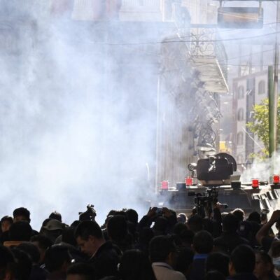 Tropas militares em veículos blindados disparam gás lacrimogêneo contra pessoas do lado de fora do Palácio Quemado, na Praça Murillo, em La Paz