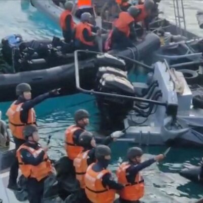 Homens da Guarda Costeira da China apontam armas brancas contra marinheiros das Filipinas