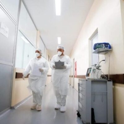 Profissionais da saúde andando em corredor de hospital