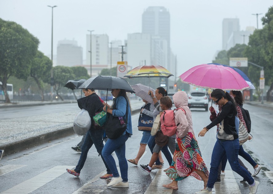Pessoas se protegem da chuva no Centro do Rio