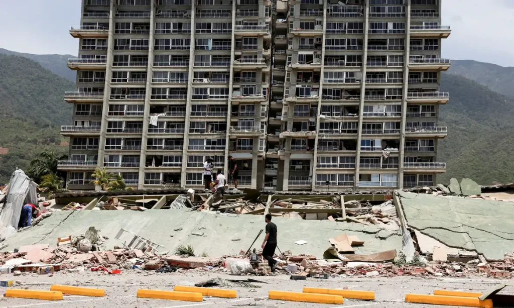 People inspect the rubble of a collapsed building after earthquakes hit the country, in La Guaira, Venezuela, June 25, 2026. REUTERS/Gaby Oraa      TPX IMAGES OF THE DAY