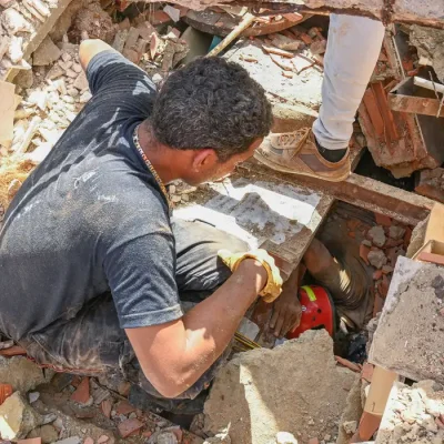 People work to rescue a man trapped under the rubble of a collapsed building, in the aftermath of earthquakes in La Guaira, Venezuela, June 25, 2026. REUTERS/Maxwell Briceno