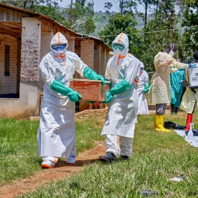 Red Cross workers wearing personal protective equipment (PPE) carry a coffin with the dead body of a child who died of Ebola, as aid agencies intensify efforts to contain a new Ebola outbreak involving the Bundibugyo strain in Mongbwalu, Djugu Territory, Ituri province, Democratic Republic of Congo, May 24, 2026. The child's parents remain at the isolation centre at the Mongbwalu General Referral Hospital. REUTERS/Gradel Muyisa Mumbere