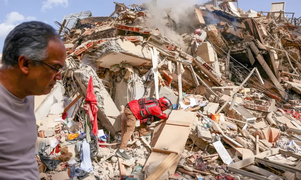 Juan Carlos Gomez, firefighter from Caracas, looks for his sister, Katiuska Hernandez, and nephew Brett Roude, amid the rubble of a building, after earthquakes hit the country, in La Guaira, Venezuela, June 25, 2026. REUTERS/Gaby Oraa