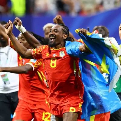 Soccer Football - FIFA World Cup 2026 - Group K - DR Congo v Uzbekistan - Atlanta Stadium, Atlanta, Georgia, U.S. - June 27, 2026 DR Congo's Samuel Moutoussamy celebrates with their national flag after the match as they qualify for the knockout stages of the World Cup REUTERS/Bernadett Szabo     TPX IMAGES OF THE DAY