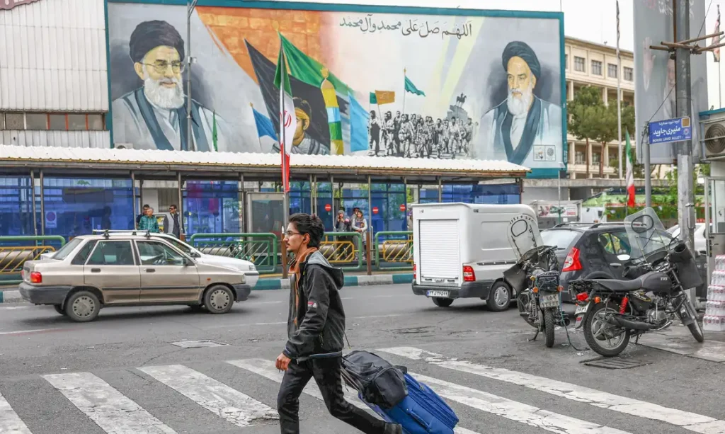 People walk next to a mural depicting the late leader of the Islamic Revolution Ayatollah Ruhollah Khomeini and the late Supreme Leader of Iran Ayatollah Ali Khamenei, in Tehran, Iran, April 12, 2026. Majid Asgaripour/WANA (West Asia News Agency) via REUTERS ATTENTION EDITORS - THIS PICTURE WAS PROVIDED BY A THIRD PARTY
