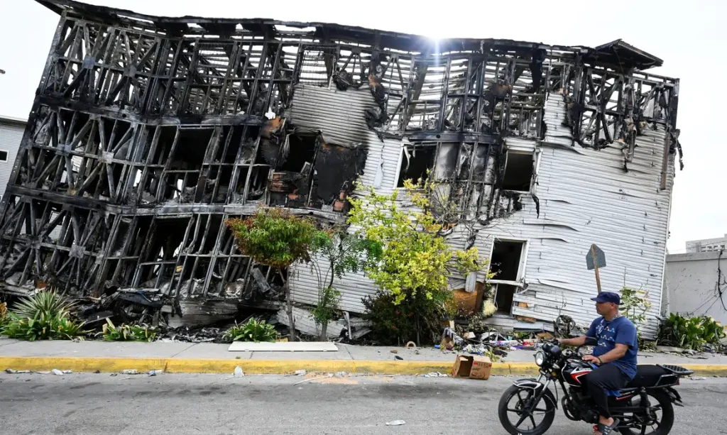 A motorist rides past a damaged building, after earthquakes hit the country, in La Guaira, Venezuela, June 28, 2026. REUTERS/Maxwell Briceno