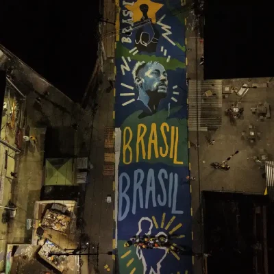 15/06/2026 - Rio de Janeiro - Pintura ressignifica rua marcada por operação letal no Rio de Janeiro. imagem aérea da rua pintada na penha com cores da seleção brasileira. Foto: Cadu Maia/Divulgação