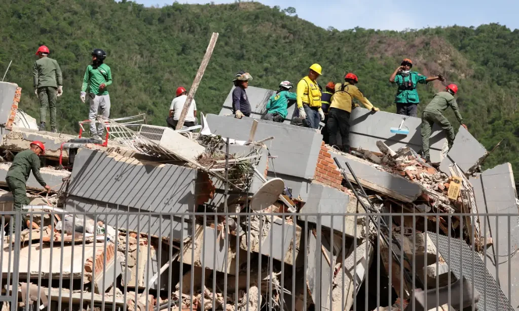 People search for casualties amid the rubble of a collapsed building in the aftermath of earthquakes in Caracas, Venezuela, June 25, 2026. REUTERS/Leonardo Fernandez Viloria