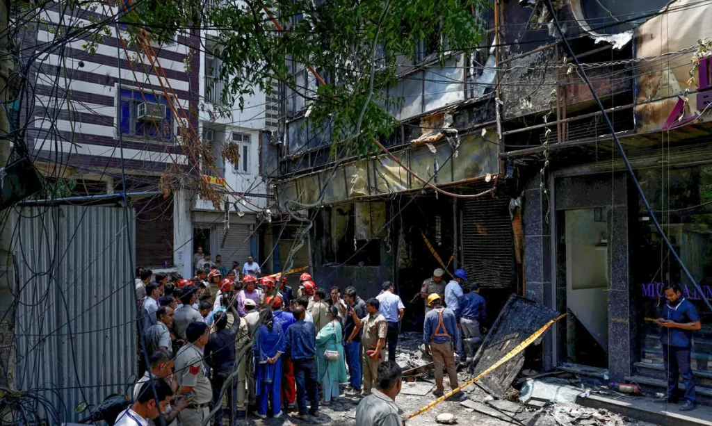 Firefighters and police officers stand at the site after a fire at a hotel in New Delhi, India, June 3, 2026. REUTERS/Adnan Abidi