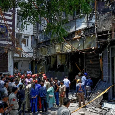 Firefighters and police officers stand at the site after a fire at a hotel in New Delhi, India, June 3, 2026. REUTERS/Adnan Abidi