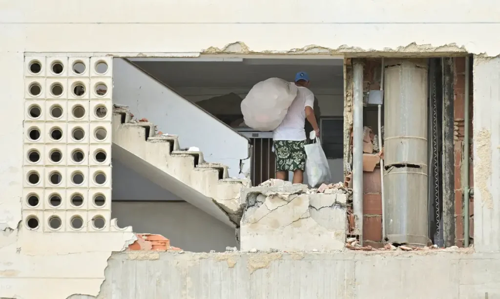 A man carrying belongings walks in a damaged building, after earthquakes hit the country, in La Guaira, Venezuela, June 28, 2026. REUTERS/Maxwell Briceno     TPX IMAGES OF THE DAY