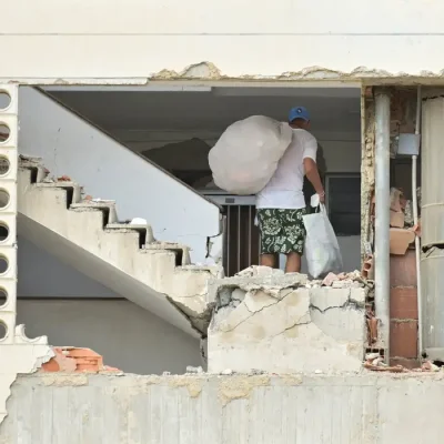 A man carrying belongings walks in a damaged building, after earthquakes hit the country, in La Guaira, Venezuela, June 28, 2026. REUTERS/Maxwell Briceno     TPX IMAGES OF THE DAY