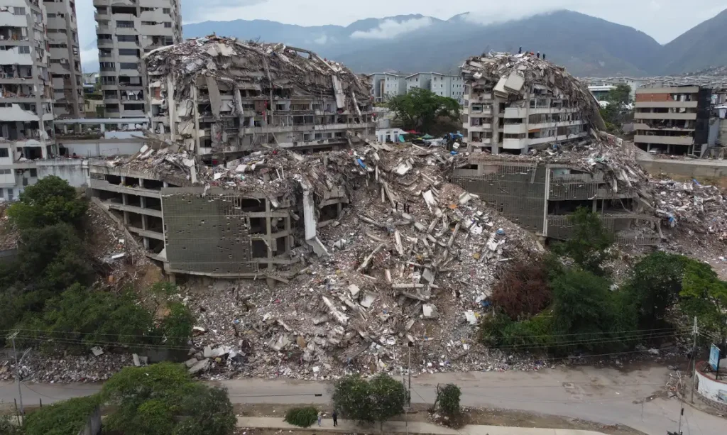 Imagem captada por um drone mostra pessoas em cima das ruínas de um prédio desabado, vasculhando os escombros após os terremotos de 24 de junho em Catia La Mar, La Guaira, Venezuela
12 de julho de 2026
REUTERS/Leonardo Fernandez Viloria