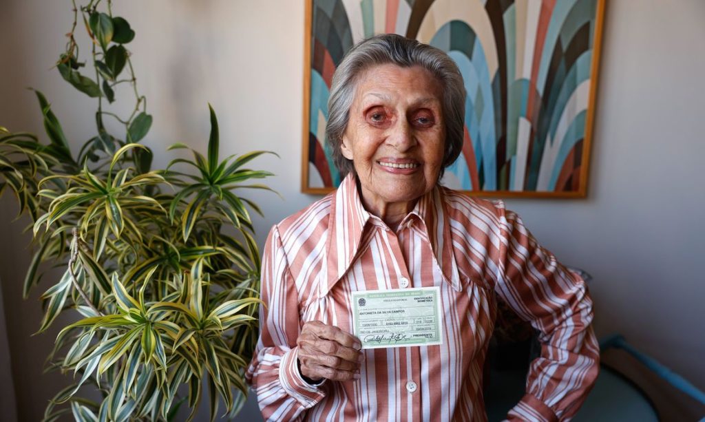 Rio de Janeiro (RJ), 10/07/2026 - Antonieta da Silva Campos, 96 anos, bancária aposentada, exibe seu título de eleitor em sua casa. Foto: Tânia Rêgo/Agência Brasil