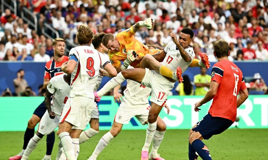 Soccer Football - FIFA World Cup 2026 - Quarter Final - Norway v England - Miami Stadium, Miami Gardens, Florida, U.S. - July 11, 2026 England's Jordan Pickford collides with Morgan Rogers after he punches the ball clear REUTERS/Dylan Martinez/Proibida Reprodução
