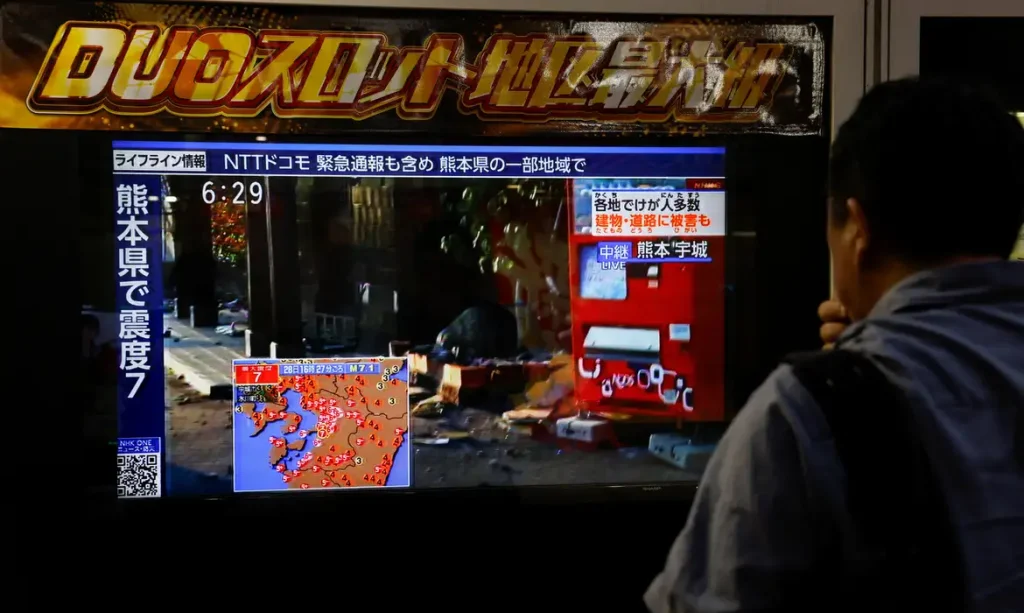 Pessoa observa uma tela que mostra os danos em uma rua após um terremoto com magnitude preliminar de 7,1 ter atingido a província de Kumamoto, no sul do Japão
28 de julho de 2026
REUTERS/Manami Yamada