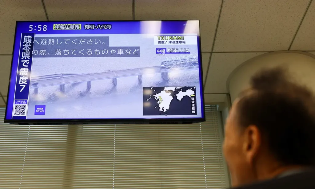 Tela de televisão exibindo imagens de uma ponte desabada após um terremoto com magnitude preliminar de 7,1 ter atingido a província de Kumamoto, no sul do Japão, em Tóquio, Japão, em 28 de julho de 2026
REUTERS/Issei Kato