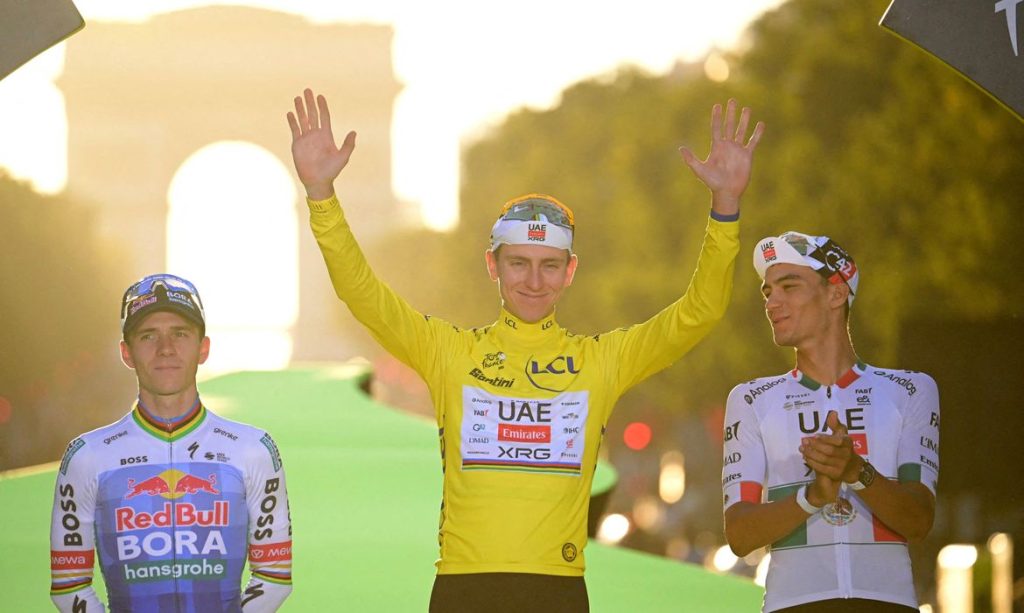 Cycling - Tour de France - Stage 21 - Paris, France - July 26, 2026 UAE Team Emirates XRG's Tadej Pogacar celebrates on the podium while wearing the yellow jersey after winning the Tour de France, alongside UAE Team Emirates XRG's Isaac Del Toro wearing the white jersey Pool via REUTERS/Papon Bernard/ Proibida Reprodução