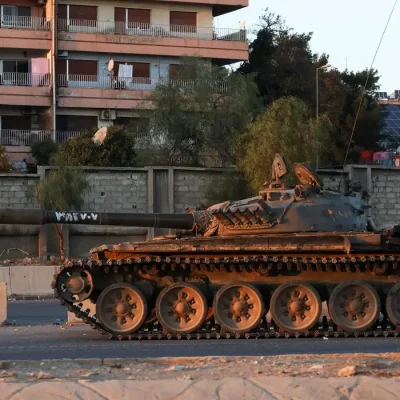 Síria- 08/12/2024  Pessoas passam  por um tanque que pertencia ao Exército Sírio, depois que rebeldes sírios anunciaram que derrubaram Bashar al-Assad da Síria, em Damasco, Síria, 8 de dezembro de 2024. REUTERS/Mohamed Azakir/ Reprodução proibida.