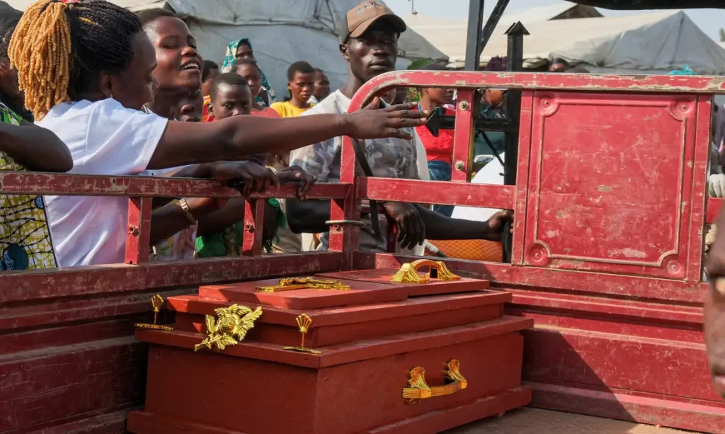 Parentes e amigos de pessoas deslocadas choram ao lado do caixão de uma suposta vítima do Ebola antes do enterro no campo de deslocados de Kigonze, em Bunia, no leste da República Democrática do Congo 18 de junho de 2026 REUTERS/Gradel Muyisa Mumbere