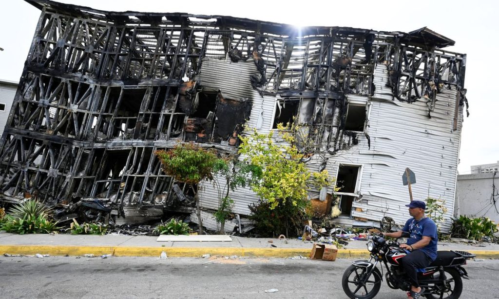 A motorist rides past a damaged building, after earthquakes hit the country, in La Guaira, Venezuela, June 28, 2026. REUTERS/Maxwell Briceno