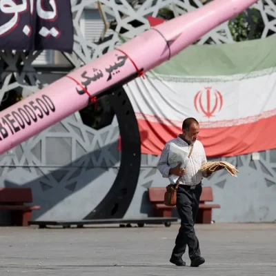 A man walks next to a symbolic mockup of an Iranian missile and an Iranian flag at Imam Hussein Square in Tehran, Iran, July 12, 2026. Foto: Majid Asgaripour/WANA/REUTERS/Proibida reprodução