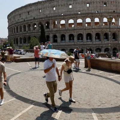 Uma pessoa segura um guarda-chuva enquanto outras caminham perto do Coliseu durante uma onda de calor que atinge toda a Itália
3 de agosto de 2026
REUTERS/Remo Casilli/Proibida Reprodução